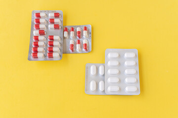 Blister with capsules and pills, isolated on a yellow background. Medicine concept.