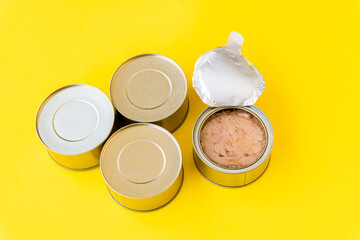 Selective focus to an open tuna can isolated on a yellow background. 
