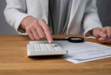 Contract, calculator and agents hand calculating budget for loan agreement.