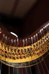 A part of a harp in stage light with bokeh. A music instrument common to classical orchestra.