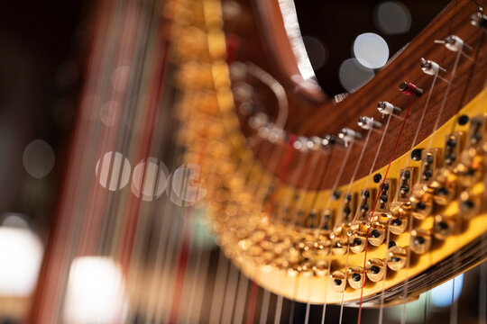 A part of a harp in stage light with bokeh. A music instrument common to classical orchestra.