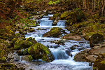 Fototapeta na wymiar Beautiful autumn landscape of flowing cascade water in a mountain river