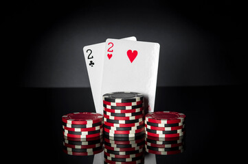 Poker game with one pair combination. Chips and cards on black table. Successful and win