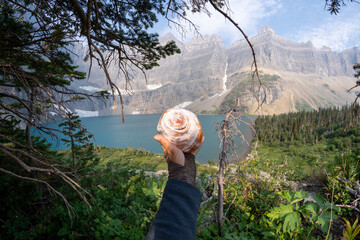 Iceberg Lake trail in Glacier National Park Montana - hiker's hand holds a large cinnamon roll