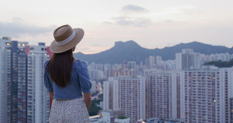 Fototapeta premium Woman look at the city of Hong Kong at sunset
