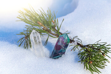 Magic still life with fluorite crystal on snow among spruce branches. Rocks for mystic ritual,...
