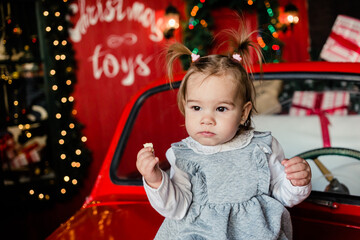 baby sitting on red Christmas car