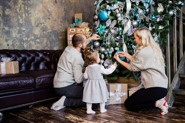 Family with child decorate Christmas tree