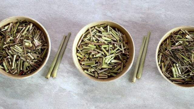 Bowls with cut lemon grass drying. Organic herb. Camera slide. Top view.