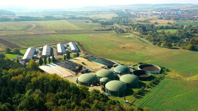 Biogas plant and farm in fields. Renewable energy from biomass. Agriculture prepared for Green Deal. Aerial view to Czech industry. Sustainable development in European Union. 