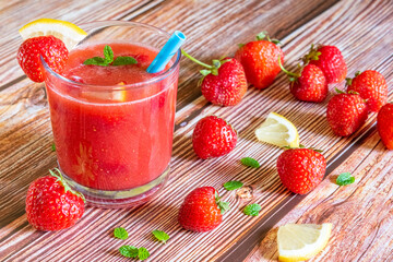 Glass of fresh strawberry smoothie on wooden background