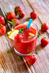 Glass of fresh strawberry smoothie on wooden background