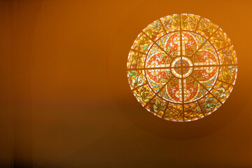 A round stained glass window with light leaks and artifacts coming from a glass prism