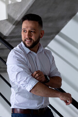 Obraz premium fashionable man posing in trendy apartment in a white button down shirt