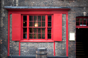 Window with red shutters, decorated with a drawing with a horse in a traditional Christmas style...