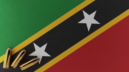 Three 9mm bullets in the bottom left corner on top of the national flag of Saint Kitts and Nevis
