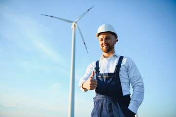 Engineer in wheat field checking on turbine production