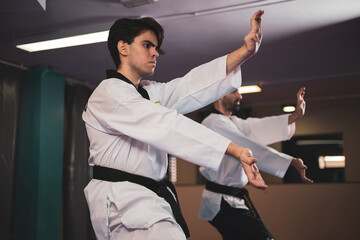 a taekwondo master training with a student in a gym.
martial art concept.