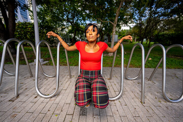 Woman modeling by a metal bike rack in the park