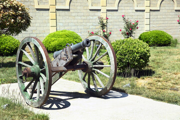 old cannon stands in the park in summer. horizontal frame . A cannon that shoots cores. Burning wick. The current model of an old artillery gun . old cannon weapons .