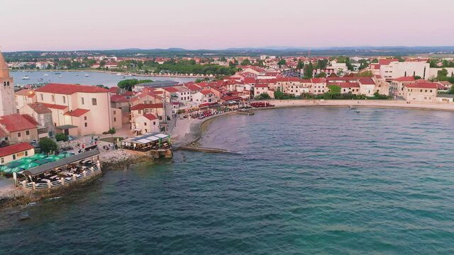 Drone flight along the promenade of the Croatian coastal town Umag during the sunset