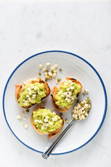Avocado toasts with mung bean sprouts on a plate. Healthy vegan appetizer or snack. Top view copy space for text, grey cement background