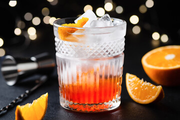 Creative fusion alcohol cocktail in whiskey glass over black background