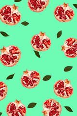 Halved pomegranate with seeds pattern on a sea green background, Contemporary food flat lay