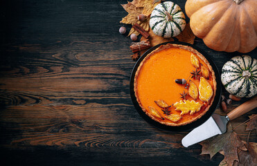 Autumn baking background with pumpkin pie pumpkin yellow autumn leaves on wooden background
