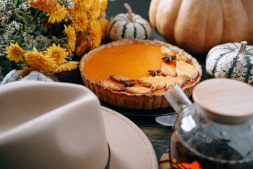 Autumn baking background with pumpkin pie pumpkin yellow autumn leaves on wooden background