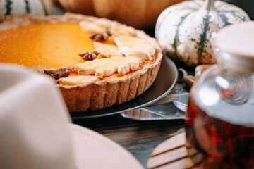 Autumn baking background with pumpkin pie pumpkin yellow autumn leaves on wooden background