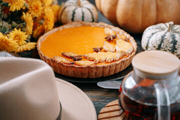 Autumn baking background with pumpkin pie pumpkin yellow autumn leaves on wooden background