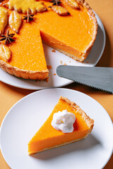 Delicious Fresh Homemade Thanksgiving Pumpkin Pie with a sliced wedge ready to be eaten