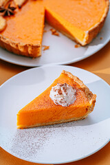 Delicious Fresh Homemade Thanksgiving Pumpkin Pie with a sliced wedge ready to be eaten