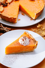 Delicious Fresh Homemade Thanksgiving Pumpkin Pie with a sliced wedge ready to be eaten
