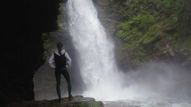 Woman Look at Splashing Waterfall. Tourist Contemplating Mountain River Flow