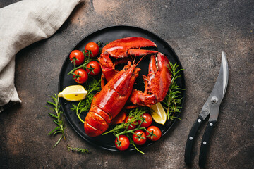 Delicious freshly cooked lobsters on black plate. Top view. Seafood and holiday concept. Gourmet food