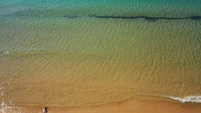 Benidorm,Spain.Aerial 4K video from drone to Benidorm Playa de Levante beach and also high rise hotels and offices.Beach is full of blue parasols and people sunbathing and swimming in the Balearic Sea