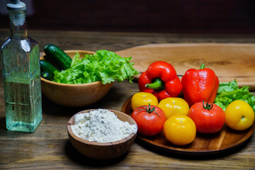 wooden bowl of flour, vegetable oil and vegetables on the kitchen table