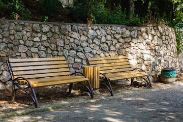 Two empty benches in shadow in nature park