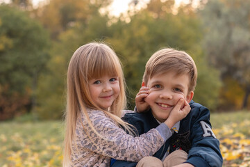 Brother and sister having fun and looking at the camera in the park