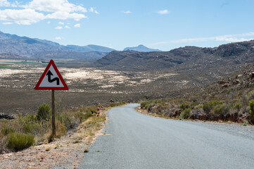 Road sign informing about dangerous curly road ahead