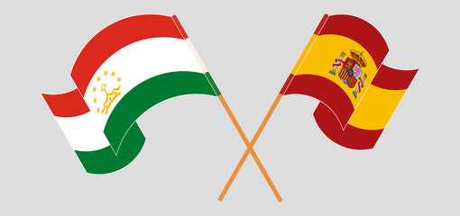 Crossed and waving flags of Tajikistan and Spain