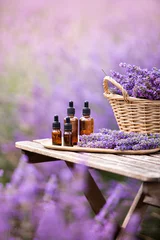 Rolgordijnen Essential lavender oil in the bottle with dropper on the gray wooden desk. Horizontal close-up. © Kotkoa