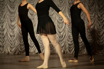 The girls rehearse the dance. Ballerinas in class. A girl in a black dress.