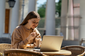 A female programmer is sitting in a summer cafe. Freelancer surf the internet information. The designer communicates with friends online. An entrepreneur prints a message on a social network.