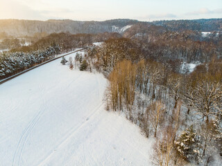 Obraz premium Beautiful aerial view of snow covered pine forests. Rime ice and hoar frost covering trees. Winter landscape near Vilnius, Lithuania.