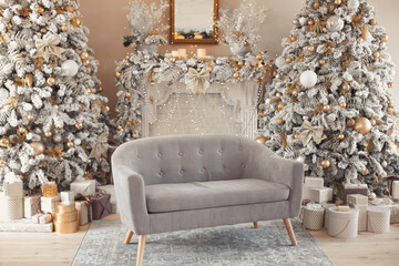 Hall room interior with a couch, fireplace with candles and decorated Christmas tree with gifts. Large designer snow tree in lounge with lights and balls in beige, brown, gold and silver colors.