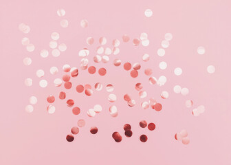 Rose gold confetti. Template for posters and banners. Top view photo. Shiny round confetti on pink...