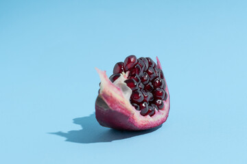 Pomegranate in shape of boat. Blue background. Creative fruit background